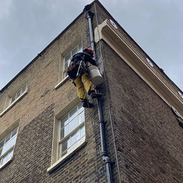 Rope access technician carrying out drainage repairs