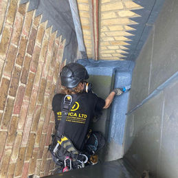 Rope access technician carrying out waterproofing application