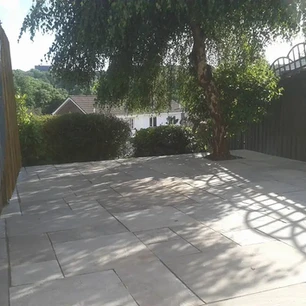 Natural stone slabs in back garden with tree.webp