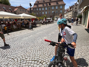 Kind mit Helm auf Fahrrad in Stadtplatz