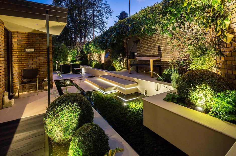Porcelain garden steps crossing a shallow pool, with clipped buxus balls and rendered raised beds