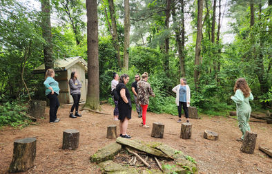 educators standing around afire pit with stumps