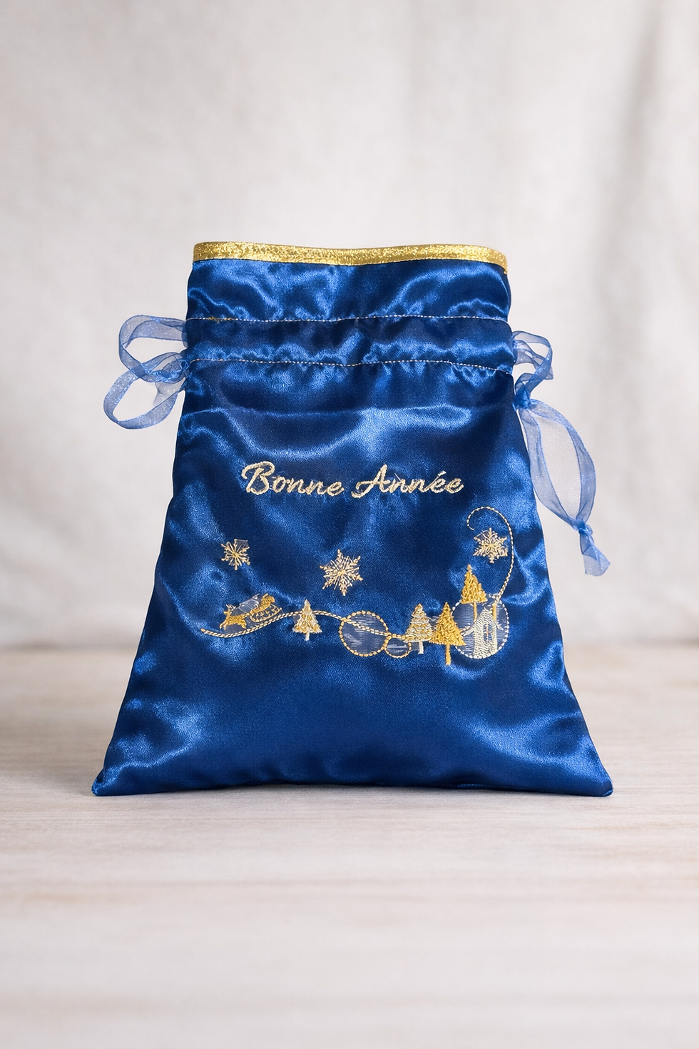Pochon en satin bleu avec lien coulissant et broderie dorée Bonne Année