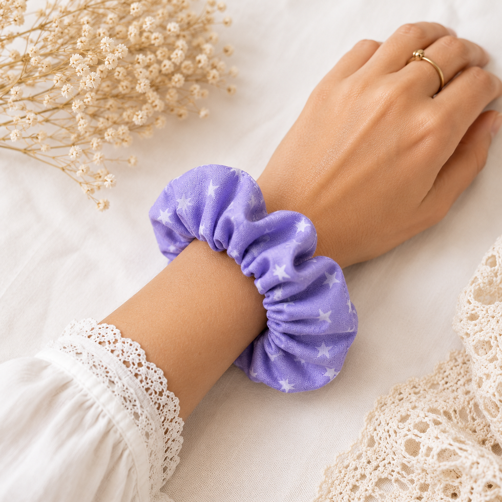 Thumbnail: Chouchou en coton violet à étoiles blanches porté sur poignet.