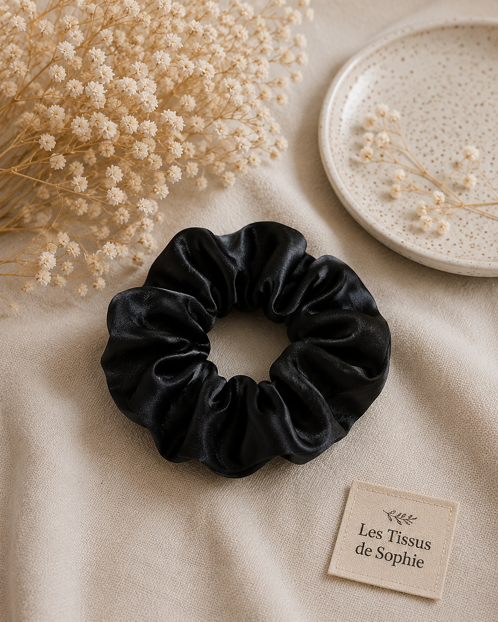 Miniature : Chouchou satin noir sur fond beige avec fleurs séchées.