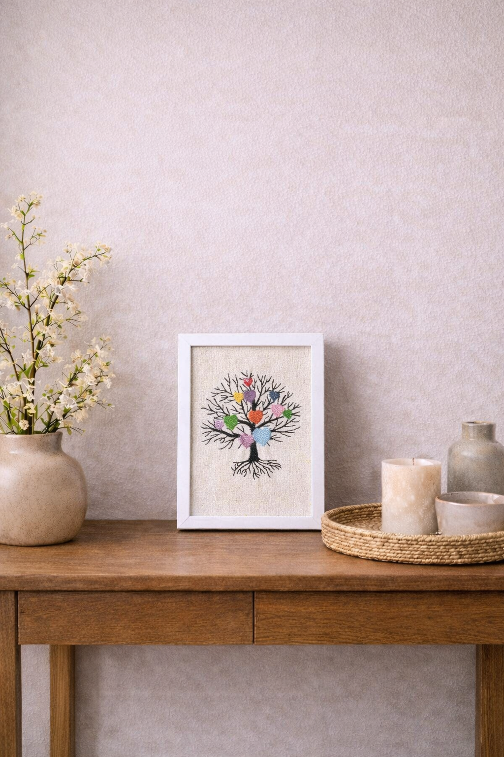Petit cadre brodé arbre aux cœurs posé sur un meuble, décoration textile artisanale