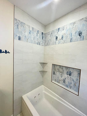 Custom shower with niche and blue accent tile