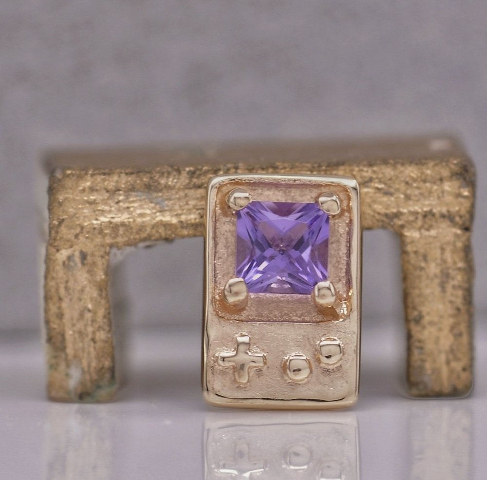 Gamer stud earring in 14K yellow gold, shaped like a handheld console with a 2×2mm amethyst screen and button details.