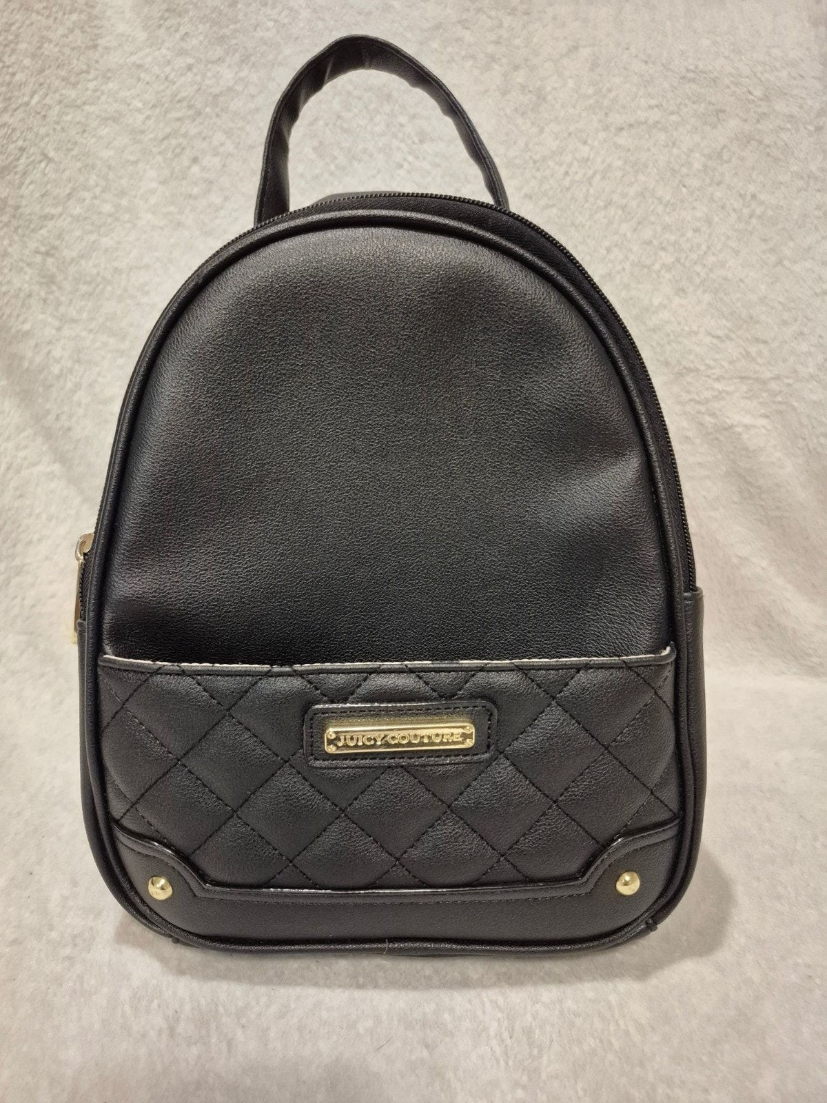 Black mini backpack with quilted front pocket and gold hardware