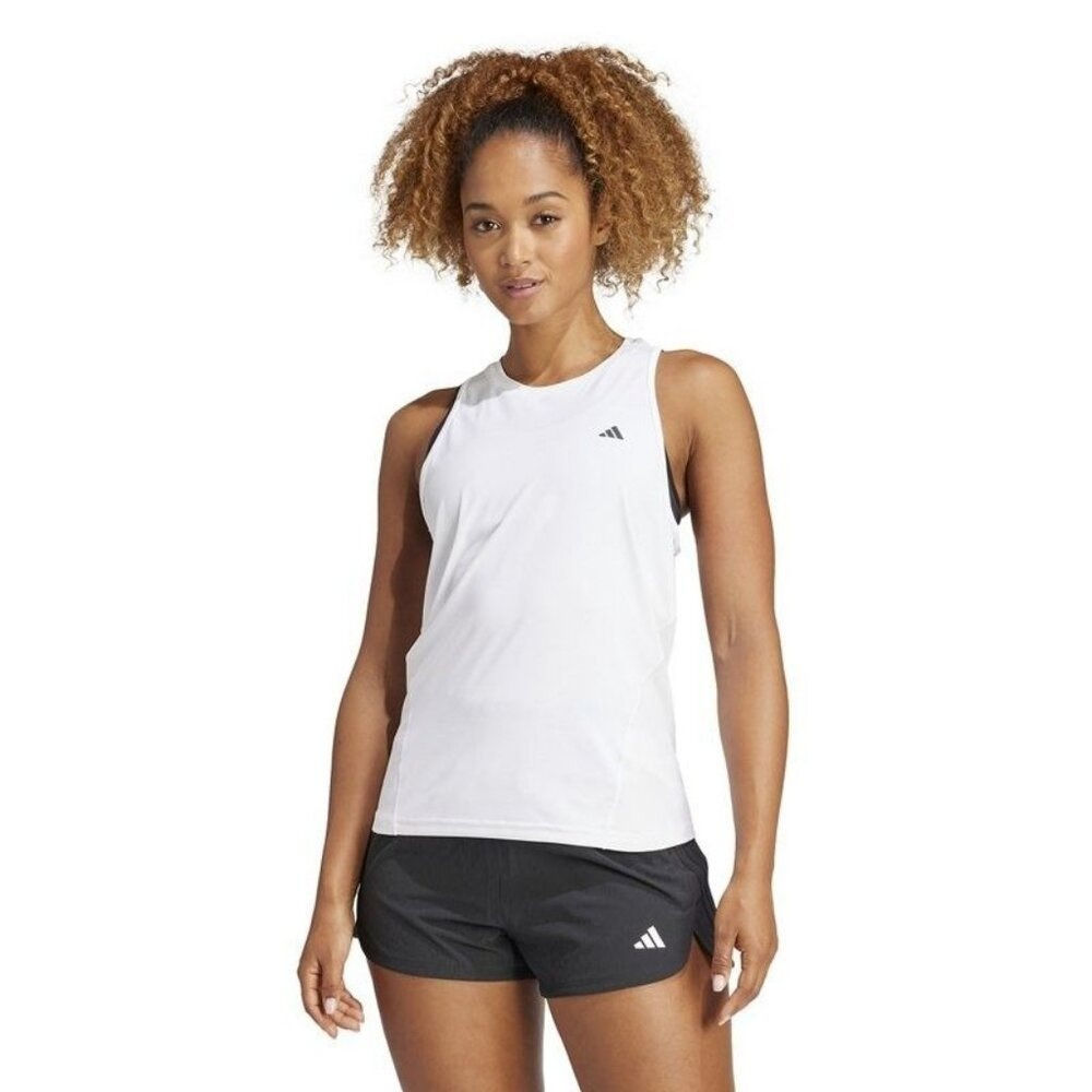 Woman wearing white sleeveless top and black athletic shorts