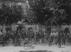 Un grup de ciclistes a la Rambla, un dels quals porta un banderí de l'entitat Sport Ciclis