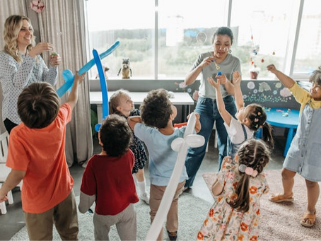 Enfants jouant joyeusement avec des bulles de savon et institutrices