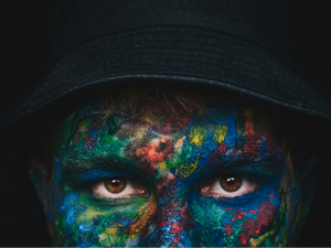 A man with facee painted with various colors
