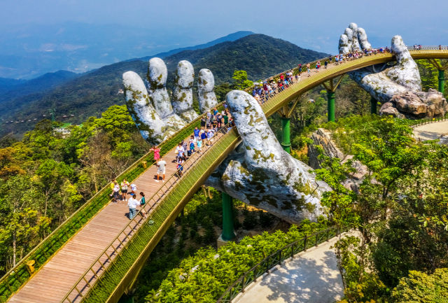 Bridge between 2 golden hands with people