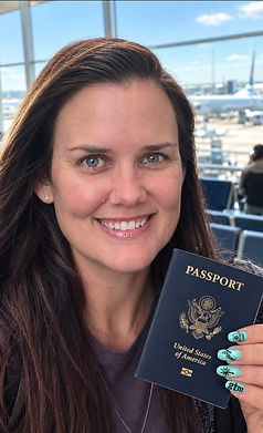 Kat Herman, Certified Travel Associate, holding her passport at the airport