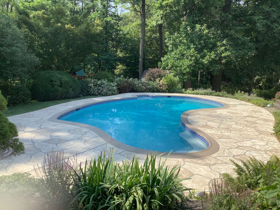 Complete concrete restoration of a backyard pool deck using RenuKrete resurfacing in a wooded setting.