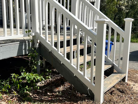 Close-up of a newly installed vinyl railing on a wooden deck in South Jersey — fresh white rails, sturdy posts, composite deck boards beneath.