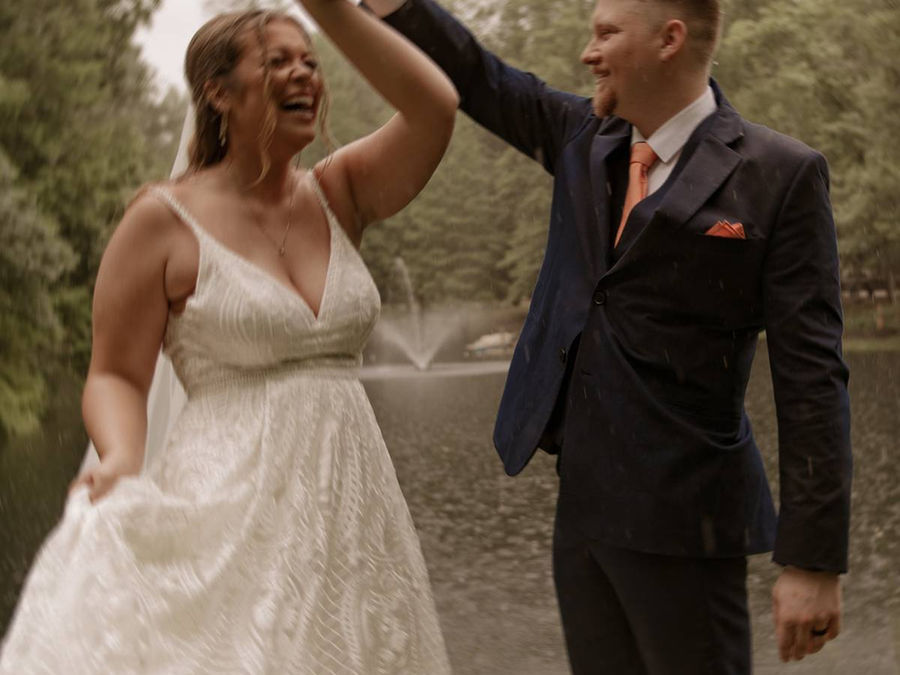 Bride and groom dancing in the rain