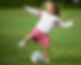 A girl plays soccer outside