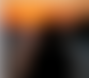 Fotografía en tonos cálidos de una persona sentada junto a una ventana, observando el paisaje con una taza en las manos, transmitiendo calma y reflexión.