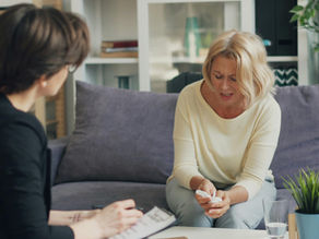 A woman in therapy talking with a young counseling intern