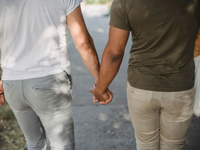 A gay couple walking holding hands