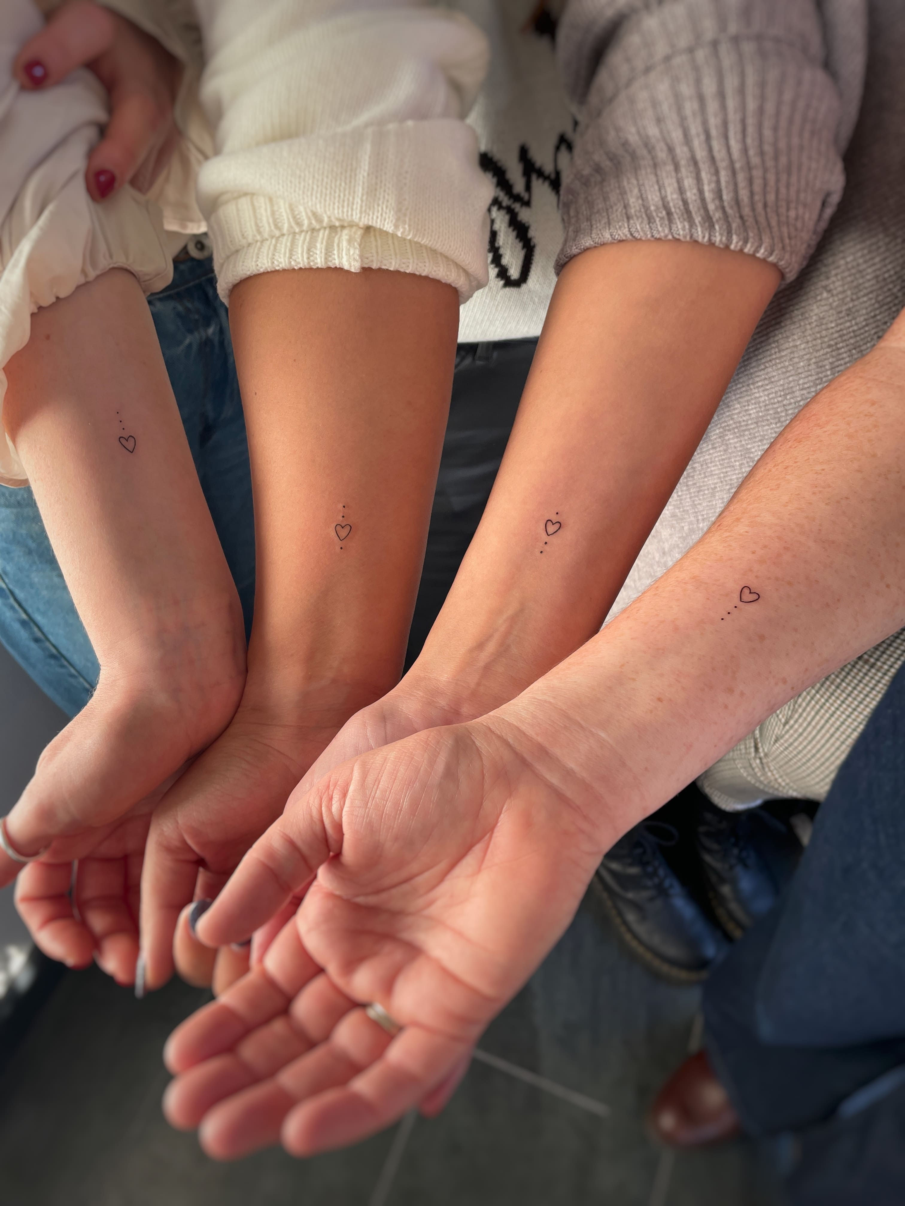 minimal floral fine line tattoo on female forearm