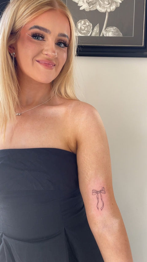 Smiling woman with small arm tattoo