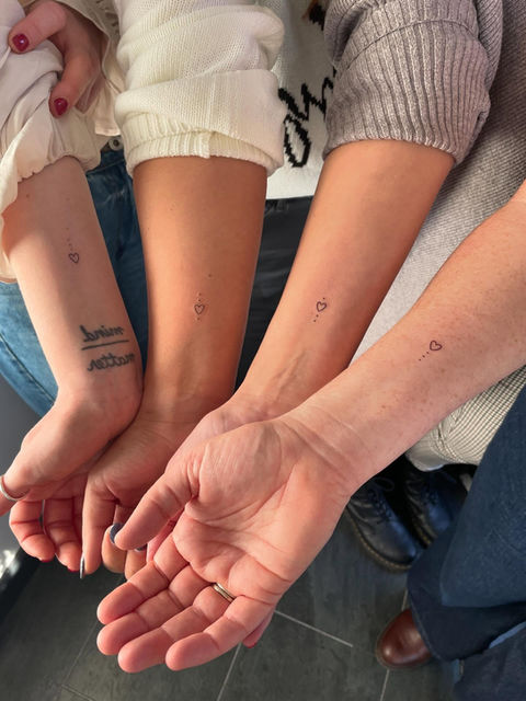 Four arms with tattoos