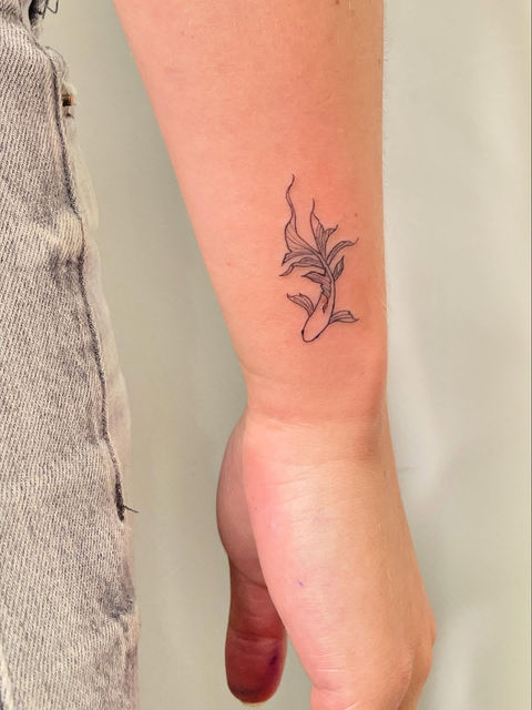 Abstract floral tattoo on inner wrist