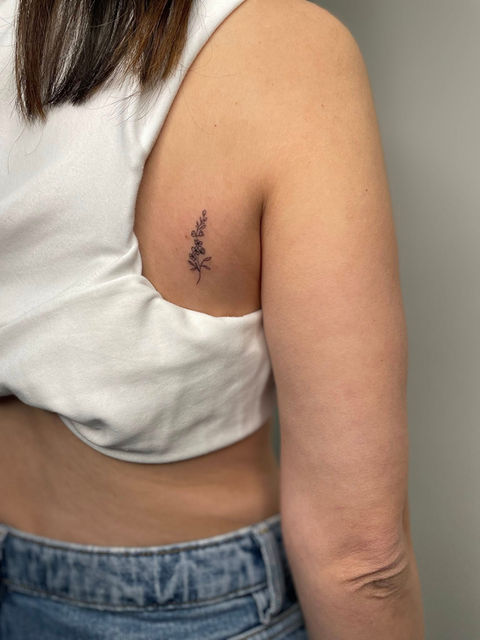 Delicate script tattoo on a person's side