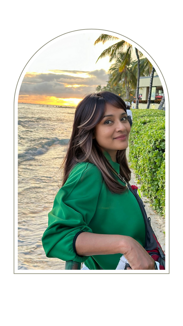 Nandini in a green top at a beach smiling at camera