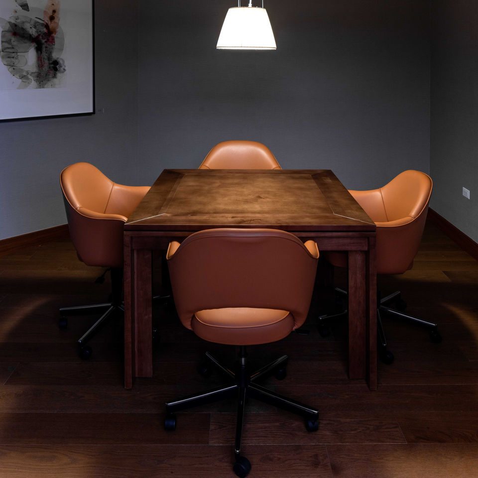A brown wooden table flanked by four leather chairs.