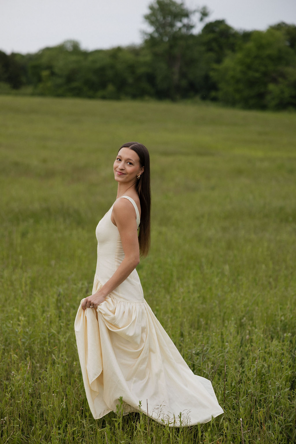 Woman in a flowing dress walking through a grassy field