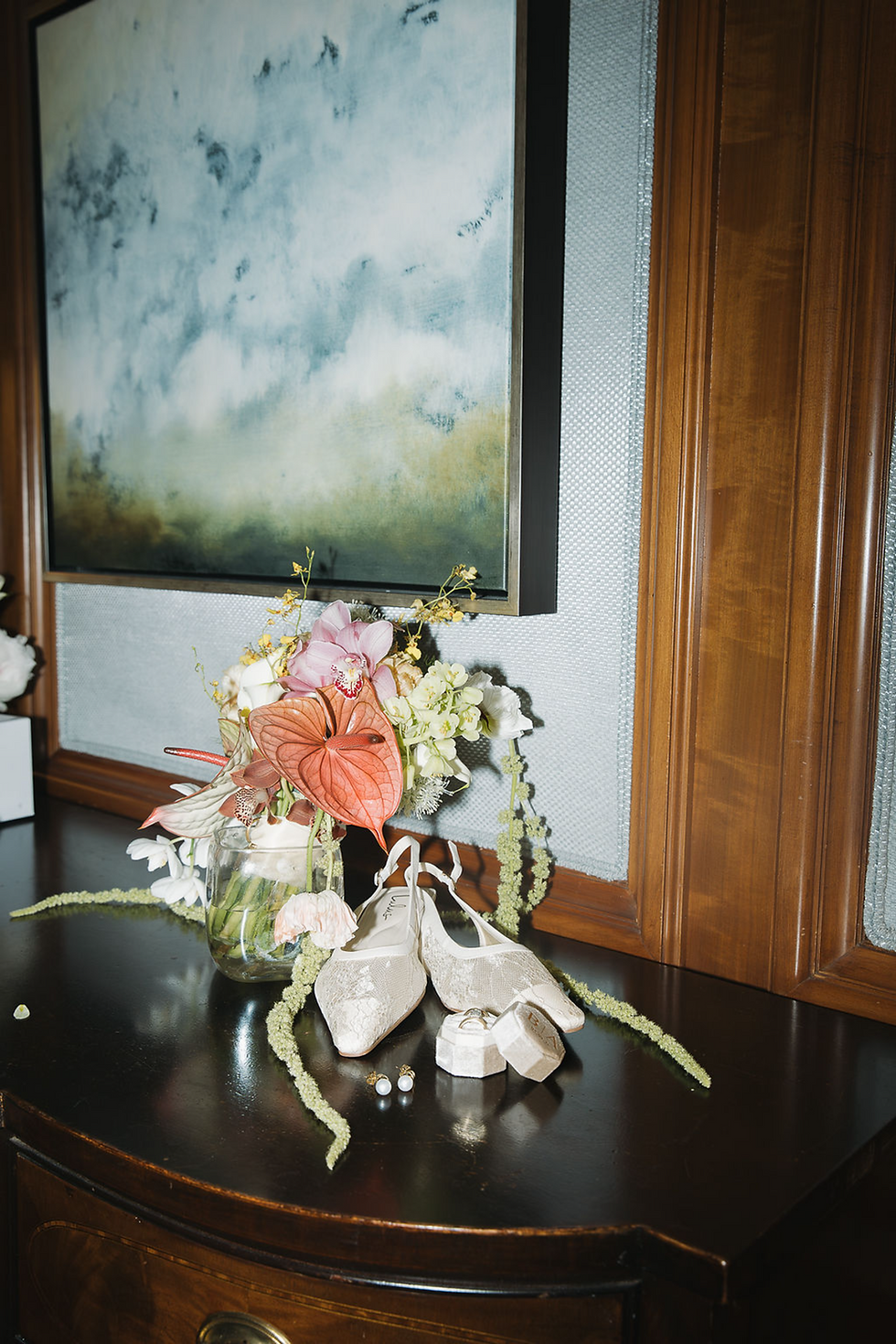 Film still of bridal flowers with colors of orange, pink and green sitting on a table with mid-century modern styling.