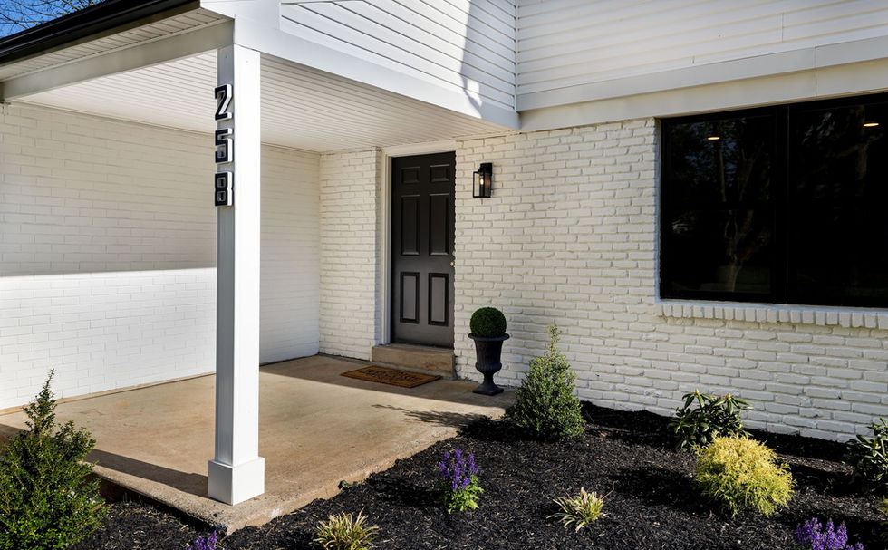 Front patio with a black painted front door next to a garden