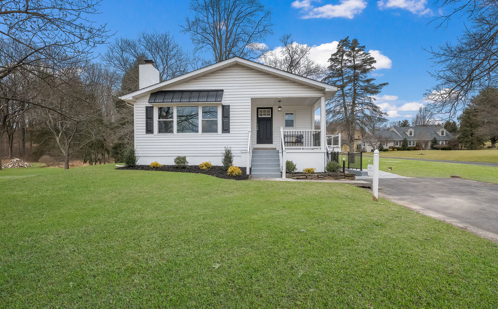 Front porch and exterior of a single family home with a large front yard