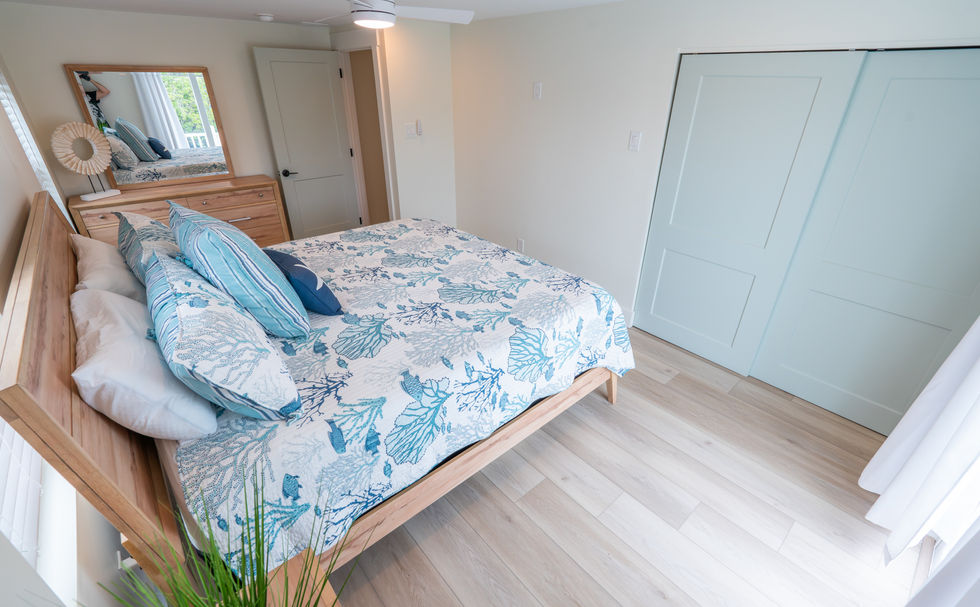 Large bedroom with sand colored wooden furniture and light gray closet doors