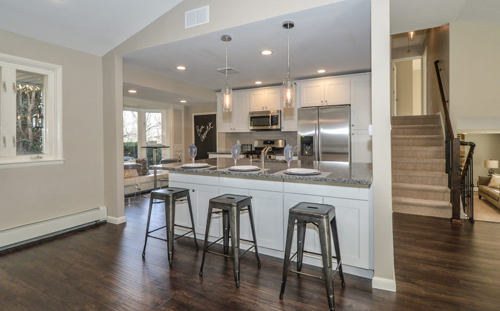 Kitchen area with built-in island on smooth, dark wood flooring