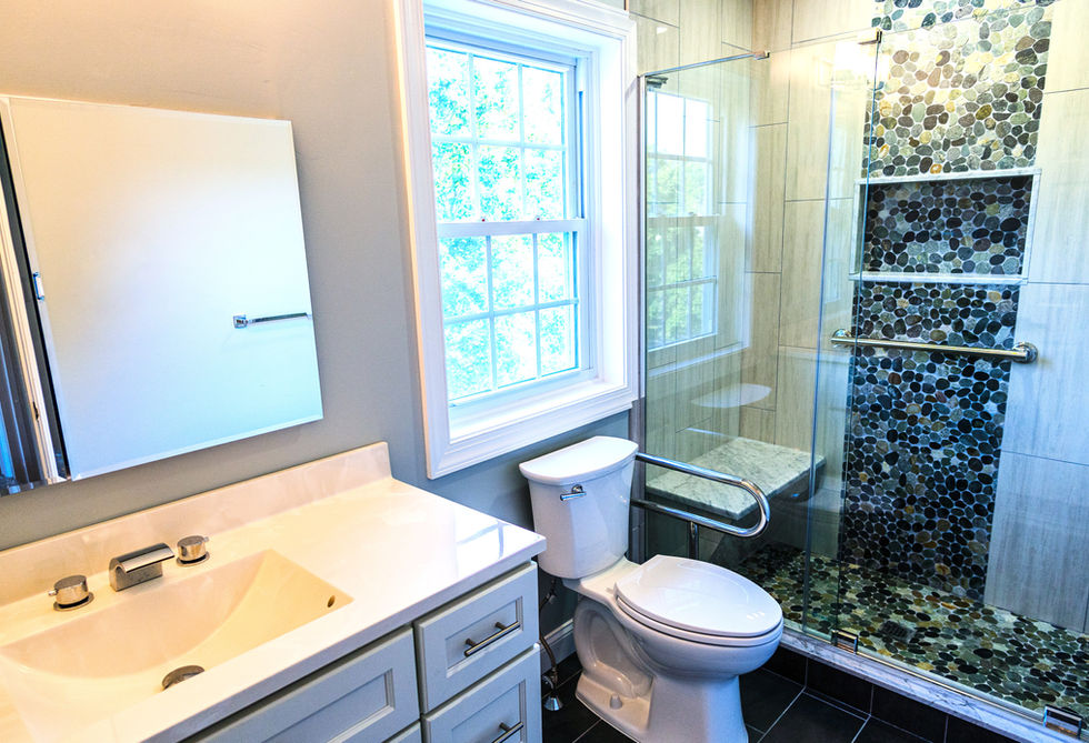 A bathroom with toilet, vanity, and a shower with glass walls