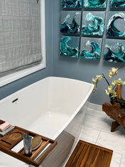 New bathroom after remodel, featuring a standalone bathtub, modern tiling, and wood accents.