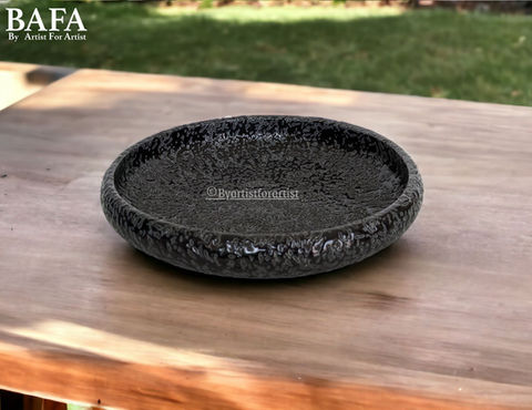 Elevate your hotel dining experience with BAFA's black dotted textured round platter. Crafted from premium ceramic stoneware, these platters are designed for both style and functionality. Dishwasher and microwave safe, as well as lead-free, they offer convenience and safety. With double the durability, they withstand daily use effortlessly. Customize them with your preferred finish to match your establishment's decor seamlessly