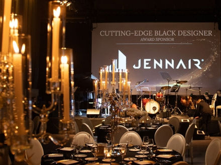 A large ballroom, filled with tables laid with tablecloths and candles