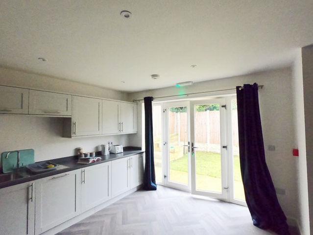 Kitchen with windowed double doors that open into the back garden.