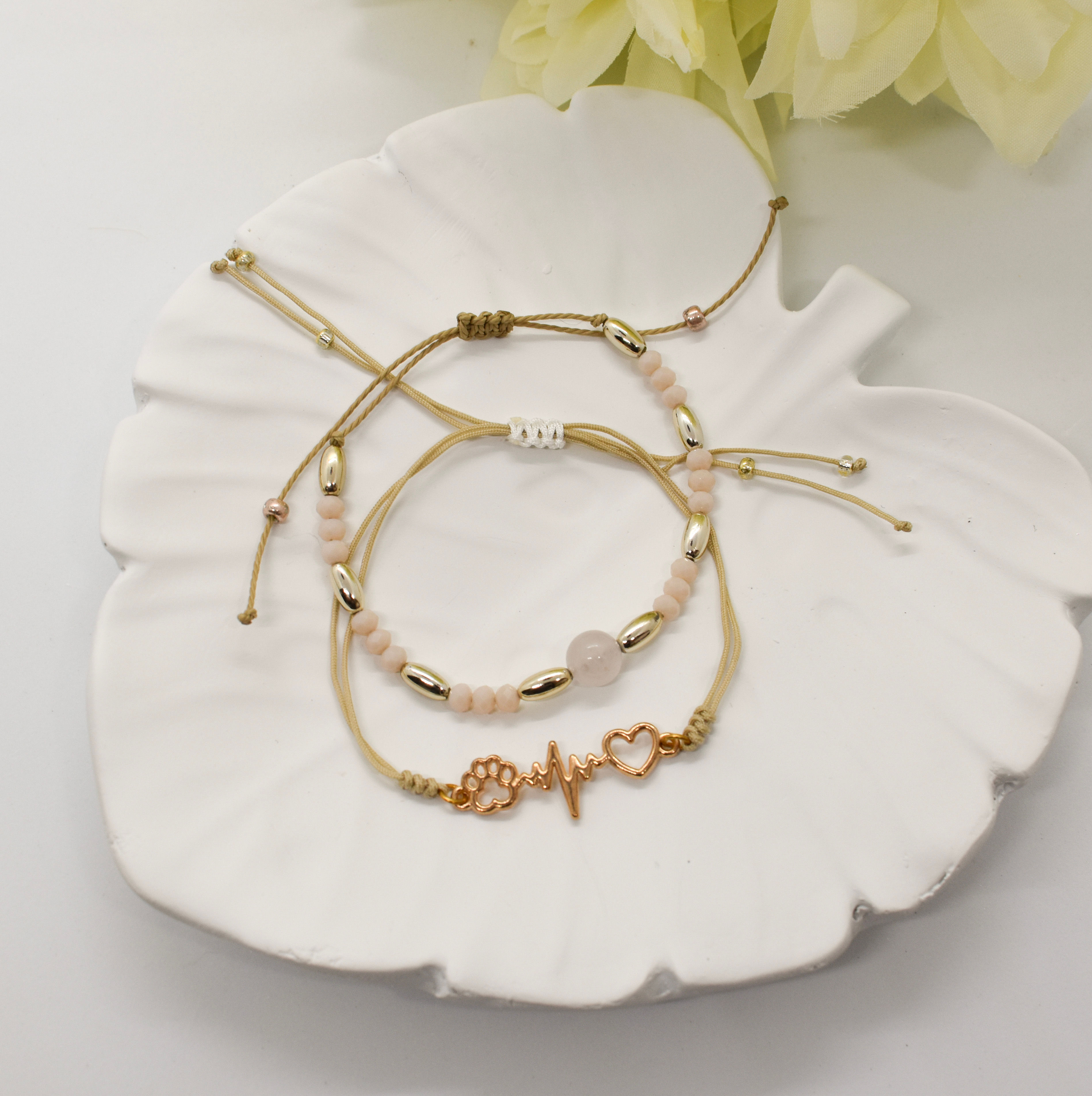 a couple of beige bracelets on a tray