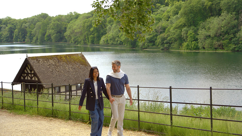 A couple take a walk near the historic lake and boathouse at Blenheim Palace