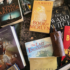 A pile of notebook and books about witches and King Arthur, lying on a blanket