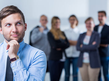 businessman qui reflechit devant une équipe de collègues