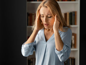 Femme qui se tient la tête avec les deux mains