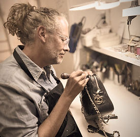 Artisan maroquinier en train d'examiner un sac